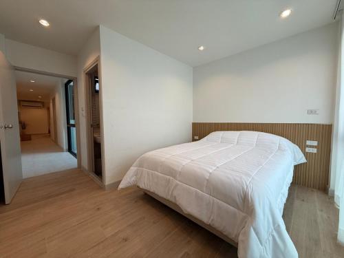 a bedroom with a white bed and a hallway at 2 Bed & 2 Bath Suite, 3rd floor in Ban Bang Toei (1)