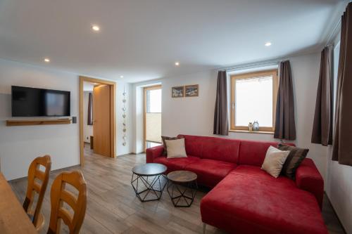 a living room with a red couch and a table at Chalet Morgenrot in Arni Alp