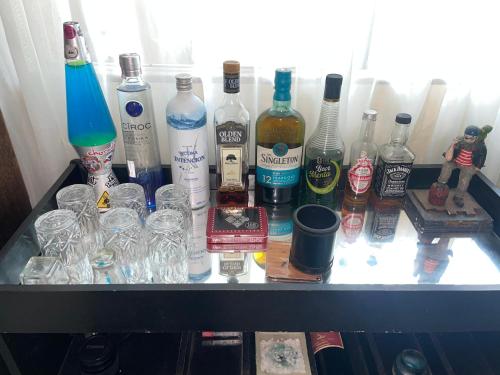 a group of bottles and glasses on a shelf at A Pérola do Gravatá in Navegantes