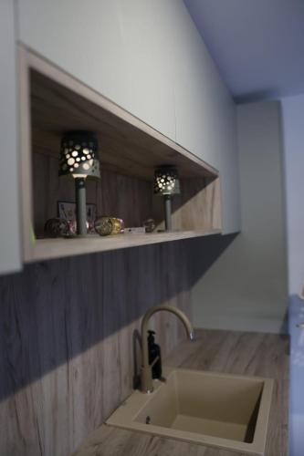 a kitchen with a sink and two lights on a shelf at Villa L&M in Bihać