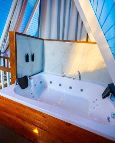 una vasca da bagno in una stanza con una finestra di Berra Resort Tatil Köyü a Eskiömerler
