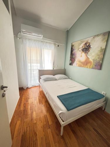 a bedroom with a bed with a painting on the wall at Alma Sea House in Hanioti