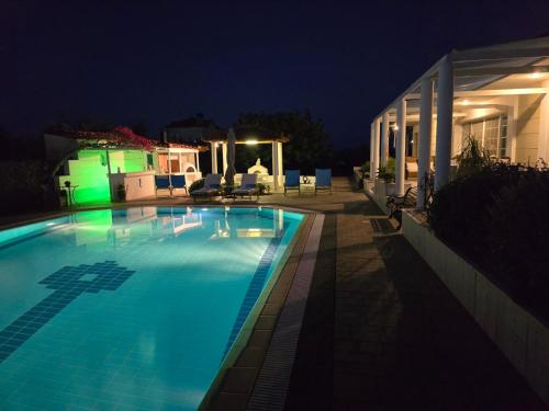 a swimming pool at night with a house at Elia Apartment in Paralion astros