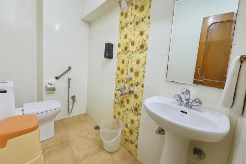a white bathroom with a sink and a toilet at The Sky Comfort Hotel Shreenath - 10 Meters from Shreenathji Temple in Nāthdwāra