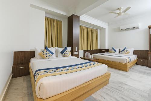 a hotel room with two beds and a ceiling fan at The Sky Comfort Hotel Shreenath - 10 Meters from Shreenathji Temple in Nāthdwāra