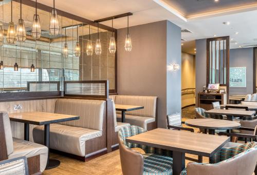 a restaurant with wooden tables and chairs at Premier Inn Dublin City Gloucester St South in Dublin