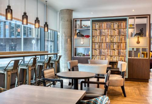 a restaurant with tables and chairs and a library at Premier Inn Dublin City Gloucester St South in Dublin