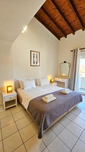 a bedroom with a large bed with two night stands at Bungalow White Apartments in Polychrono