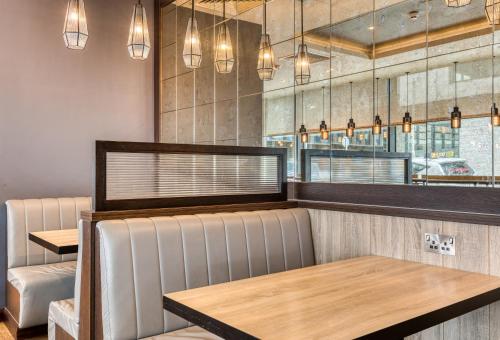 a restaurant with a table and chairs and lights at Premier Inn Dublin City Gloucester St South in Dublin