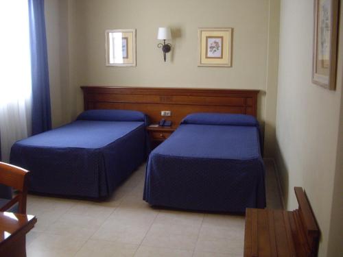 pokój hotelowy z dwoma łóżkami i stołem w obiekcie Hotel Manolo Mayo w mieście Los Palacios y Villafranca