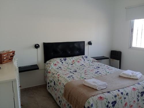 ein Schlafzimmer mit einem Bett mit zwei Handtüchern darauf in der Unterkunft Alquiler Temporario CF in San Carlos de Bolívar