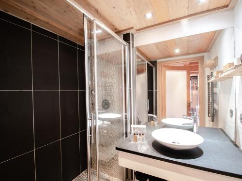 W łazience znajdują się 2 umywalki i przeszklony prysznic. w obiekcie Charmant appartement près pistes et centre, WiFi, parking privatif - FR-1-343-193 w Chamonix-Mont-Blanc