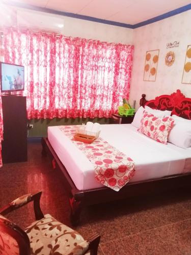 a bedroom with a bed with red curtains at Sang Yoo Mountain View Tagaytay Bed and Breakfast - Taal Lake View in Tagaytay