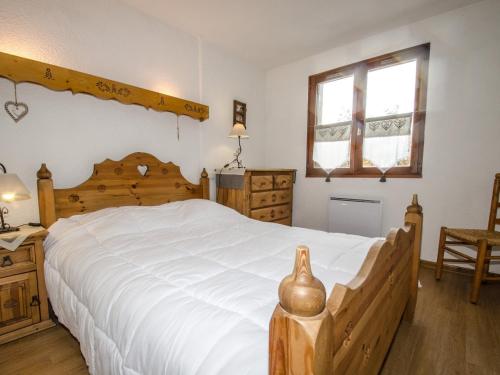 une chambre avec un grand lit blanc et une fenêtre dans l'établissement Appartement avec balcon, parking extérieur et WiFi à Chamonix - FR-1-343-245, à Chamonix-Mont-Blanc
