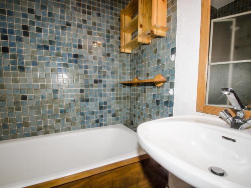 une salle de bain avec un lavabo et une baignoire dans l'établissement Appartement avec balcon, parking extérieur et WiFi à Chamonix - FR-1-343-245, à Chamonix-Mont-Blanc