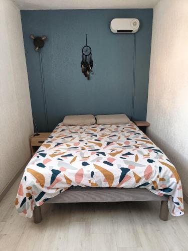 - un lit avec une couette colorée dans une chambre dans l'établissement plage, agréable, refait à neuf, top lit, hôte réactif, terrasse, soleil, paisible., à Saint-Cyprien