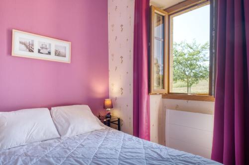 - une chambre avec des murs violets et un lit avec une fenêtre dans l'établissement L'Hirondelle - Perigord Noir, à Saint-Geniès