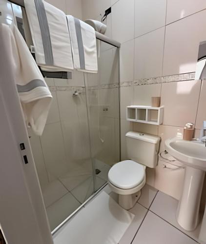 ein weißes Badezimmer mit Toilette und Dusche in der Unterkunft Apto funcional e bem equipado in Maringá