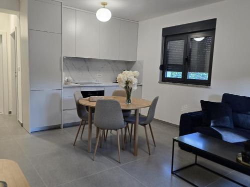 a living room with a table and chairs and a couch at Apartment Lumiere in Ljubuški