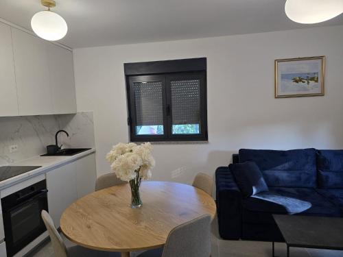 a living room with a table and a blue couch at Apartment Lumiere in Ljubuški