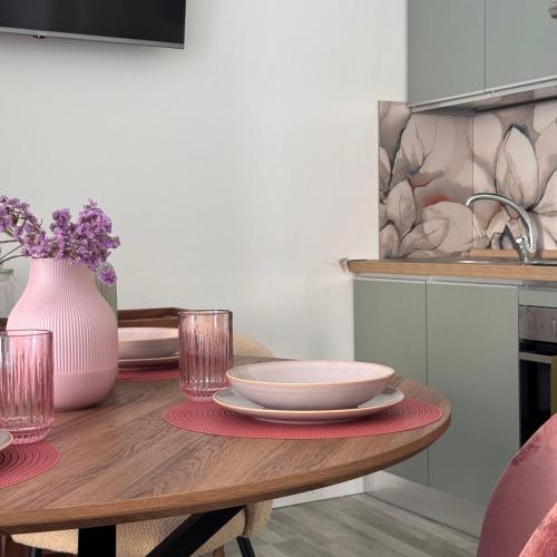 a dining room table with plates and a vase of flowers at Cocciu d'amuri a casa in Terrasini