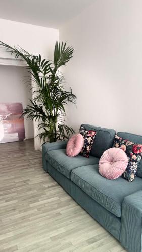 a blue couch with pink pillows in a living room at Cocciu d'amuri a casa in Terrasini