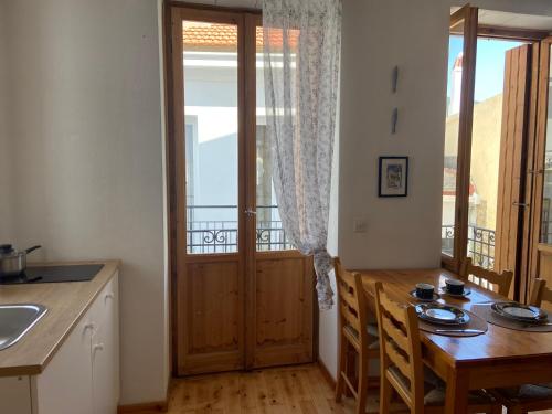 a kitchen and dining room with a table and a door at Adele house in Skopelos Town