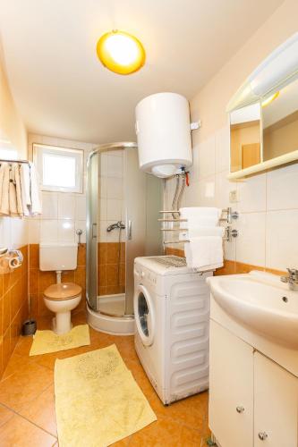 a bathroom with a washing machine and a sink at tiho's apartments in Split