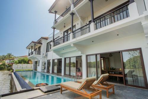 an exterior view of a house with a swimming pool at Villa Fleuve 6-BHK Riverfront Hideaway With Infinity Pool & Bathtub in Nerul