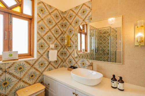 a bathroom with a sink and a mirror at Villa Fleuve 6-BHK Riverfront Hideaway With Infinity Pool & Bathtub in Nerul