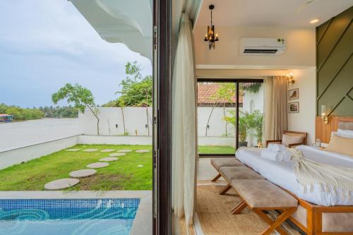 a living room with a couch and a view of a yard at Villa Fleuve 6-BHK Riverfront Hideaway With Infinity Pool & Bathtub in Nerul