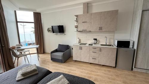 a room with a kitchen with a sink and a table at SofiCoast in Gonio
