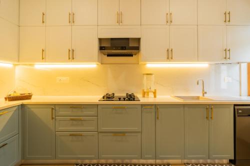 a kitchen with white cabinets and a sink at Villa Fleuve 6-BHK Riverfront Hideaway With Infinity Pool & Bathtub in Nerul