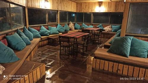 a room with blue pillows on benches and tables at Tafila-Mataan in Al Jafr