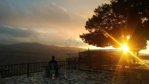 a man sitting in a chair watching the sunset at Tafila-Mataan in Al Jafr