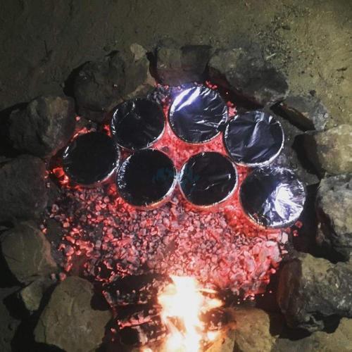 a fire pit filled with rocks and a bunch of glasses at Tafila-Mataan in Al Jafr