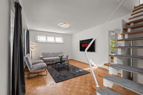 a living room with a couch and a tv at Maisonette apartment in Basel with free parking! in Allschwil