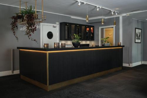a lobby with a black counter with potted plants at Home Hotel Uman in Umeå