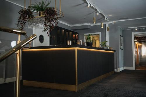 a bar in a room with plants on the wall at Home Hotel Uman in Umeå