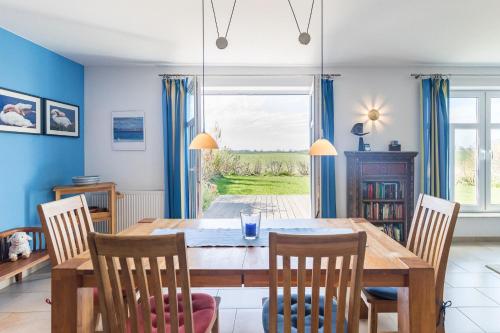 a dining room with a wooden table and chairs at Ferienhaus Am Felde in Groß Schwansee