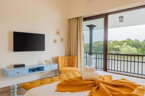 a living room with a bed and a large window at Villa Fleuve 6-BHK Riverfront Hideaway With Infinity Pool & Bathtub in Nerul