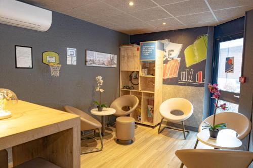 a room with chairs and tables and a basketball hoop on the wall at ibis budget Marne La Vallée Noisy Le Grand in Noisy-le-Grand