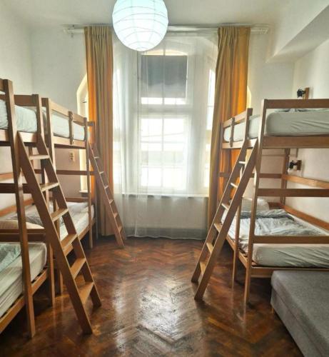 a room with four bunk beds and a window at Centrum House Hostel in Braşov