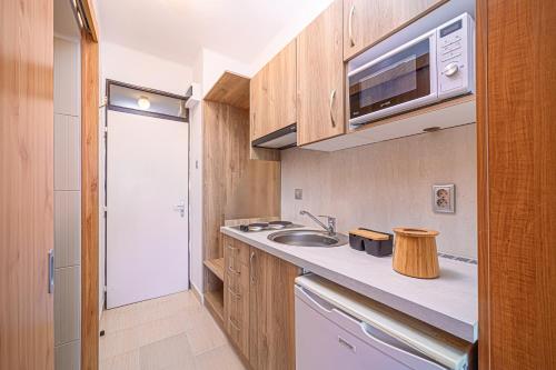 a small kitchen with a sink and a microwave at Apartman Hotel in Bük