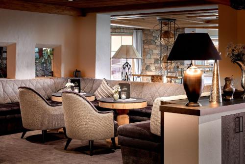 a living room with a couch and a table and chairs at Sporthotel Ellmau in Tirol in Ellmau