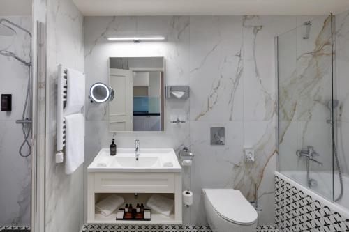 a bathroom with a sink and a toilet and a shower at Hotel Savoy Prague in Prague