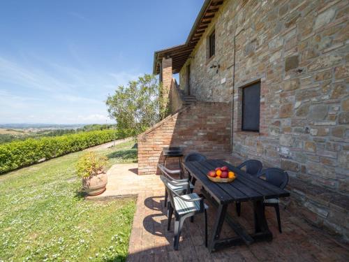 a patio with a table and chairs and a stone building at Apartment Raffaello by Interhome in Montaione