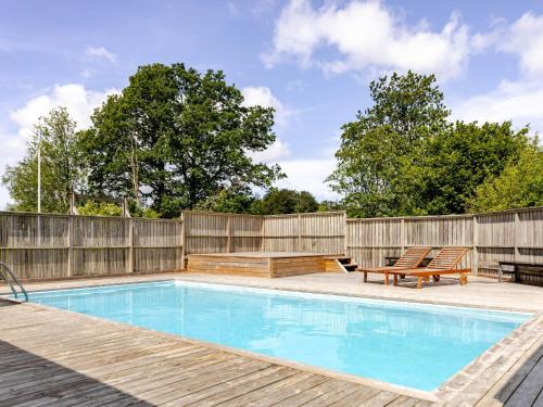 einen Pool im Hinterhof mit einem Holzzaun in der Unterkunft Chalet Kvarnfallet by Interhome in Ullared