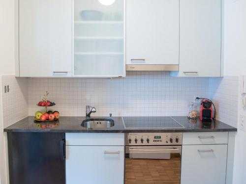 a kitchen with white cabinets and a sink at Apartment Double Room Modern-11 by Interhome in Ascona