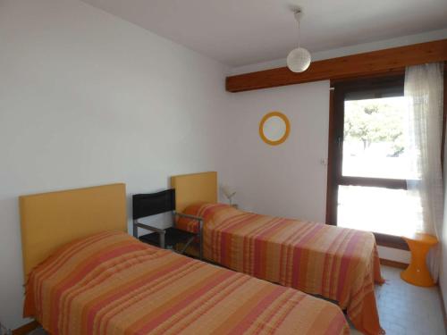 une chambre avec deux lits et une fenêtre dans l'établissement Villa Rénovée en Duplex, 8 Pers, 3 Ch, Patio, Clim, Proche Plage et Centre - La Grande-Motte - FR-1-328-109, à La Grande Motte
